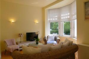 a living room with a couch and chairs and a tv at Albatros C0 in De Haan +6 photos