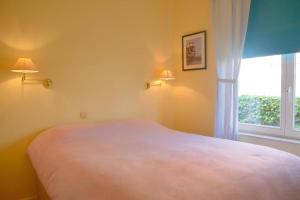 a bedroom with a bed and a window at Albatros C0 in De Haan