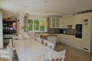a kitchen with a white table and white chairs at Summer Dream in De Haan
