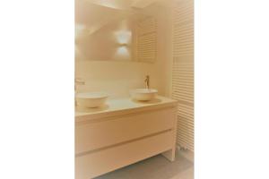 a bathroom with two sinks on top of a dresser at Summer Dream in De Haan +15 photos