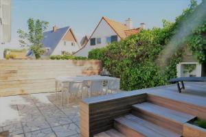 a patio with a table and a water hose at Summer Dream in De Haan