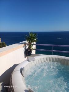 a hot tub on a balcony with the ocean in the background at Yvonne's BELA VISTA in Sesimbra