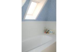 a bathroom with a white bath tub with a skylight at Albatros D2 in De Haan +4 photos