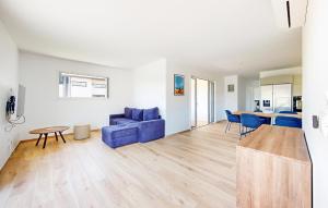 a living room with a blue couch and a table at Gorgeous Home In Vielle Saint Girons in Saint-Girons-en-Marensin
