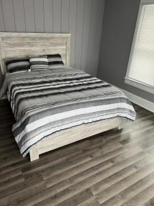 a bed in a bedroom with a wooden floor at Farmhouse in Kenosha