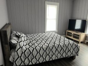 a bedroom with a bed and a television at Farmhouse in Kenosha