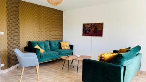 salon z zieloną kanapą i stołem w obiekcie VILLA TY EDEN - standing- dans JARDIN EXOTIQUE privé, PLAGE à 200m w mieście Clohars-Carnoët