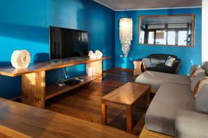 a living room with a couch and a television at Twin Palms Villa and Homestay in Tuapejat