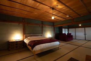 una camera da letto con un letto grande e due lampade di Satoyama Villa Honjin a Matsumoto