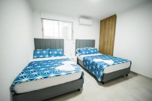 two beds in a small room with at Apartamentos cerca al mar Rodadero VIlla Dely in Gaira