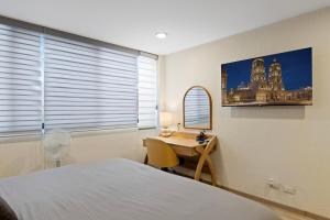 a bedroom with a bed and a desk with a mirror at Two KING Size Beds in Historic Downtown DGO in Durango