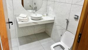 a bathroom with a sink and a toilet and a mirror at Pousada Shangrila RP in Ribeirão Preto +25 photos