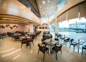 a restaurant with tables and chairs and a large window at V8 Hotel Johor Bahru in Johor Bahru
