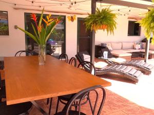 a wooden table with a vase of flowers on it at Quintessential Kewarra in Kewarra Beach