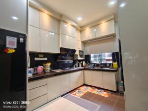 a kitchen with white cabinets and a counter top at HANS HOMESTAY in Lumut