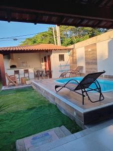 een terras met een tafel en stoelen en een zwembad bij Casa com piscina in Búzios +26 foto's