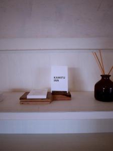 a shelf with a book and a vase on it at Kamifu INN in Kami-furano
