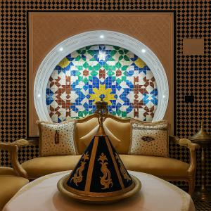 Habitación con mesa y pared de mosaico en Riad Lalla Marrakech, en Marrakech