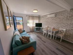 a living room with a couch and a dining room at Gloucester - 2 Bedroom Apartments in Gloucester