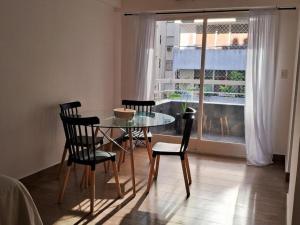 La PorteñaRecoleta, departamento de lujo a estrenar的一间设有玻璃桌、椅子和窗户的用餐室