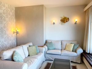 a living room with two couches and a glass table at Attic Apartment Nieuwpoort near Beach in Nieuwpoort