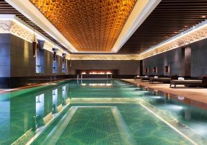 a swimming pool in a building with a large pool at Park Hyatt Changbaishan in Fusong