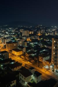 a city lit up at night with buildings at Apto aconchegante, central, prox ao carrefour in Santa Maria