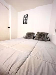 エンビガドにあるComfort Envigado 7 peopleの白いシーツが敷かれた大きなベッドのある寝室