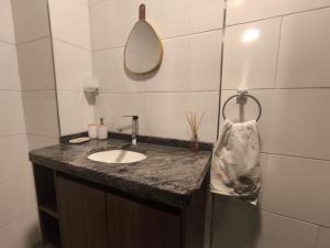 a bathroom with a sink and a mirror at Tu Refugio Acogedor a Pasos de Todo in Cochabamba +5 photos