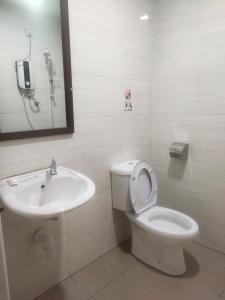 a bathroom with a white toilet and a sink at S&P Hotel in Tampin