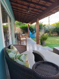 een patio met rieten stoelen op een veranda bij Casa com piscina in Búzios