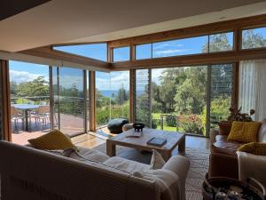 a living room with couches and a large glass window at Everlong Mollymook in Mollymook