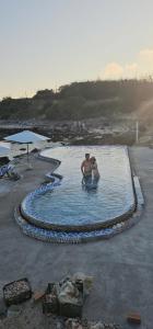 twee mensen zitten in een zwembad bij Long Vĩ hotel - đảo Phú Quý in Cu Lao Thu