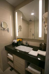 a bathroom with a sink and a mirror at V8 Hotel Johor Bahru in Johor Bahru