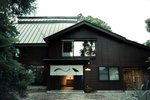 a black house with a window with a bat on it at MAHORA西野谷 古民家宿 Myoko Taditional Japanese house in Myoko