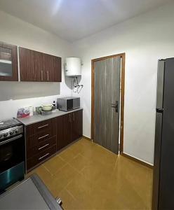 eine Küche mit Herd und Kühlschrank in der Unterkunft OBDP House in Abidjan