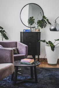 Una sala de estar con una mesa con libros y un espejo. en Apartamento de 3 Habitaciones en el Centro, en Villa María