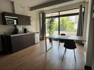 a kitchen with a table and two chairs in a room at Oak 2B Loft Ejecutivo en zona 10 in La Aurora
