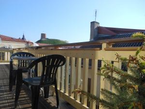 two chairs sitting on a balcony with a christmas tree at Daukanto Apartments in Vilnius