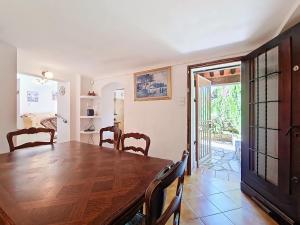 ein Esszimmer mit einem Holztisch und Stühlen in der Unterkunft Villa à Callian avec Piscine Privée, Jardin, 2 Chambres, 4 Pers - FR-1-779-13 in Callian