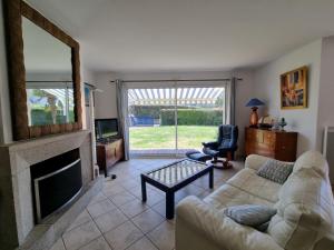 a living room with a couch and a fireplace at Maison moderne 8 pers à St Gildas de Rhuys, près du bourg et falaises - FR-1-775-29 in Saint-Gildas-de-Rhuys