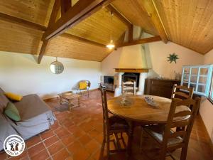 a kitchen and dining room with a table and a fireplace at Charmante chaumière traditionnelle dans le Marais breton - FR-1-426-584 in Beauvoir-sur-Mer +5 photos