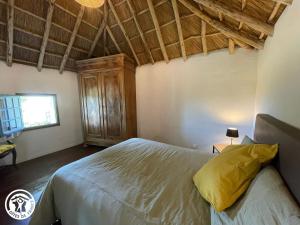 a bedroom with a bed and a wooden ceiling at Charmante chaumière traditionnelle dans le Marais breton - FR-1-426-584 in Beauvoir-sur-Mer
