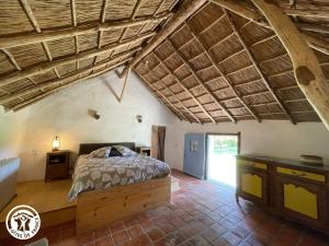 ein Schlafzimmer mit einem Bett und einer Holzdecke in der Unterkunft Séjour Authentique en Bourrines Traditionnelles à Beauvoir-sur-Mer - FR-1-426-583 in Beauvoir-sur-Mer