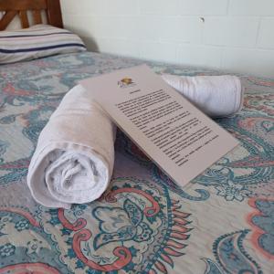 a towel and a book laying on a bed at Chalé Completo Com Linda Vista para o Mar de Ilhabela 2 in Ilhabela