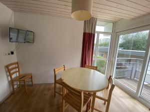 a dining room with a table and chairs and a television at Apartment in Saâles with Heated Pool in Saales