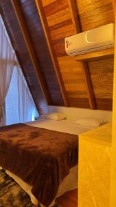 two beds in a room with a roof at Chales da Ilha in Alter do Chao