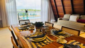 a wooden table with plates and dishes on it in a living room at Chales da Ilha in Alter do Chao
