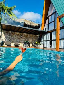 a person holding a glass in a swimming pool at Chales da Ilha in Alter do Chao +18 photos