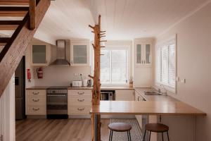 cocina con mesa y 2 taburetes en Little Swanport River Haven, en Little Swanport
